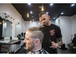 Eddy Mesho cuts a customer's hair in Saskatoon at his new location on Broadway. (Kayle Neis/Saskatoon StarPhoenix)