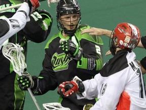 Saskatchewan Rush Brett Mydske and Calgary Roughnecks Mike Carnegie tangle up in NLL action at the Scotiabank Saddledome in Calgary.