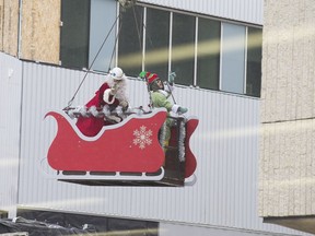 Santa Claus waves to a crowd from the Jim Pattison Children's Hospital construction site during a fly-by of Royal University Hospital on Thursday, Dec. 21, 2017. Santa got off his sleigh and brought presents to children in the hospital.