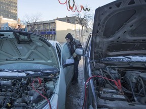 Bob Ammazzini helps boost a car on a cold day in downtown Saskatoon, on Tuesday, December 26, 2017.