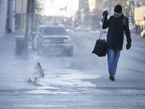 Devon Finlay walks past a water main break on the corner of 3rd Avenue and 3rd Street East in Saskatoon, SK on Friday, December 29, 2017. We head into 2018 on a cold note as Arctic-like weather continues to plague much of Saskatchewan.