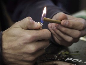 A man lights a marijuana cigarette in Denver on Tuesday, April 25, 2017. A vast majority of Canadians who participated in a recent government survey believe pot use could be habit forming.THE CANADIAN PRESS/Joe Mahoney