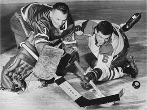 Toronto Maple Leafs goalie Johnny Bower uses his famous pokecheck to knock the puck away from Montreal Canadiens' forward Ralph Backstrom during a 1964 game.