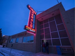 Doug Lix (left) and Kevin Mitchell, who have both drawn paycheques from the Times-Herald, look up at the paper's neon sign.