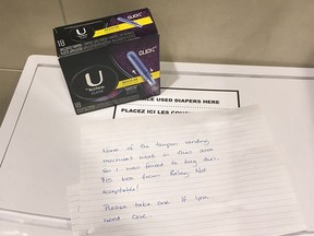 An anonymous note and a $15 box of tampons is shown in a women's washroom at the Calgary International Airport on Nov. 26, 2017. Though many shocked at the price, women in remote Indigenous communities often pay that much or more for feminine hygiene products, according to the organization Moon Time Sisters