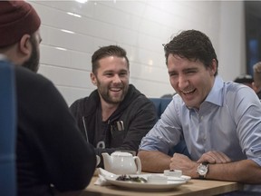 Prime Minister Justin Trudeau speaks to people as they eat breakfast at Hometown Dinner in Saskatoon on Friday, December 8, 2017.