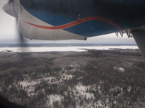 A file photo shows a plane flying near Fond du Lac, Saskatchewan in December 2014.