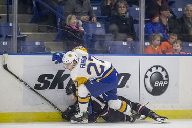 Saskatoon Blades forward  Michael Farren pushes Red Deer Rebels forward  Grayson Pawlenchuk into the boards during first period WHL action in Saskatoon, SK on Friday, January 5, 2017.