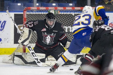 Red Deer Rebels goalie  Riley Lamb attempts to stop a shot that would be a goal for Saskatoon Blades forward  Braylon Shmyr during first period WHL action in Saskatoon, SK on Friday, January 5, 2017.