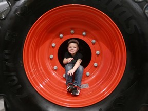 Five-year-old Easton Will climbs out of a tractor wheel at the 35th Western Canadian Crop Production at Prairieland Park in Saskatoon on January 9, 2018. The annual trade show, which aims to connect farmers with new tools and technology, runs through Jan. 11.