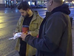 Liam Murphy signs his name to the Fight For 15 Saskatchewan petition outside of Midtown Plaza on Friday, Jan. 19, 2017. Members of the organization are collecting petitions calling on the provincial government to raise minimum wage to $15. The group feels Saskatchewan's current minimum wage of $10.96 isn't enough for people to get by on.