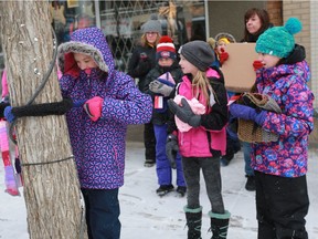The Jr Youth Group at St Martin's United Church tie scarves they knit and crocheted to posts and trees downtown Saskatoon on January 28, 2018 with a note saying "If you are cold please take this scarf. From the Jr Youth at St Martin's United Church"