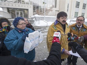 Patricia Whitebear, left, holds up a baby sweater that was kept by the mother of Robert Doucette, right, after he was taken into foster care during the Sixties Scoop. Doucette filed a lawsuit against the federal and provincial governments at Saskatoon Court of Queen's Bench on Jan. 29. Both are expected to attend a rally and march in Saskatoon today in support of Indigenous people affected by the child welfare system, part of a national day of solidarity.