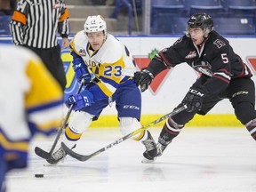 Saskatoon Blades forward Braylon Shmyr goes against Red Deer Rebels defenceman  Dawson Barteaux during the game at SaskTel Centre in Saskatoon, SK on Wednesday, January 31, 2018.