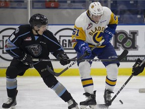 Kootenay Ice forward Peyton Krebs fights for the puck against Saskatoon Blades forward Josh Paterson during WHL action Jan. 6 at the SaskTel Centre in Saskatoon.