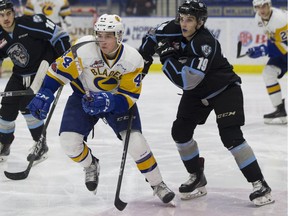 Saskatoon Blades forward Chase Wouters skates in front of Kootenay Ice forwards (L TO R) Colton Veloso and Peyton Krebs during the game at SaskTel Centre in Saskatoon, SK on Saturday, January 6, 2018.