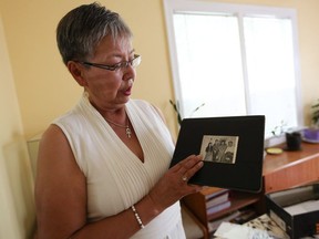 Senator Lillian Dyck looks through family photos at her home in Saskatoon.