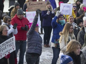 Claudia Manning (center) holds up a sign during the Women's March Canada event near river landing in Saskatoon, SK on Saturday, January 20, 2018.