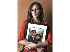 FILE - In this May, 15, 2014, file photo, Kim Goldman holds a photo of her with her late brother, Ron Goldman, killed along with his friend Nicole Brown Simpson in 1994, during an interview at her home in Santa Clarita, Calif. A lawyer for the family of Fred Goldman says O.J. Simpson is profiting from autographs since his release from prison and should pay the money toward a wrongful death judgment exceeding $70 million. Attorney David Cook plans to ask a Los Angeles Superior Court judge Tuesday, Jan. 30, 2018, to order Simpson to hand over future money he makes autographing sports memorabilia to satisfy the judgment in the wrongful deaths of Ron Goldman and Simpson's ex-wife Nicole Brown Simpson.