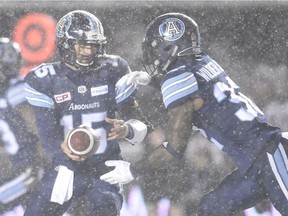 Toronto's Ricky Ray hands the ball to James Wilder during a snowy Grey Cup this past November in Ottawa.