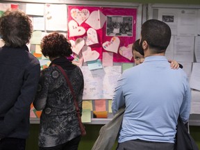 People look at messages of sympathy during a gathering at the Centre Islamique de Quebec, marking the first anniversary of the mosque shooting, Saturday, January 27, 2018 in Quebec City.