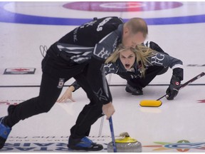 Jennifer Jones and Mark Nichols bring a stone into the house during round robin play at the Canadian mixed doubles curling Olympic trials.