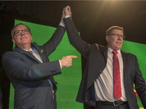 Outgoing Saskatchewan Premier Brad Wall, left, lifts the arm of Scott Moe, who won the Saskatchewan Party party leadership and becomes the new Saskatchewan premier, during the leadership convention in Saskatoon on Saturday, Jan. 27, 2018.