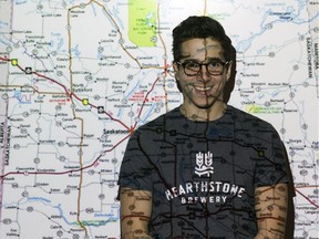 Saskatchewanderer 2017 Andrew Hiltz stands in front of a projected map of Saskatchewan in Regina.