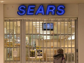 A woman walks past the shuttered Sears in the St. Vital Centre in Winnipeg on Sunday.