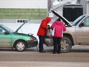 A man helps boost a woman's truck that stopped working on Taylor Street East in Saskatoon on February 8, 2018.