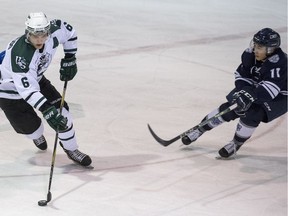 U of S Huskies defence Jordan Fransoo moves the puck away from Mount Royal University Cougars forward Jamie King during the second period of CIS hockey action at Rutherford Rink in Saskatoon, February 10, 2018.