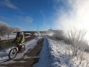 A cyclist rides up Spadina Crescent with steam coming off the river in Saskatoon on February 21, 2018.
