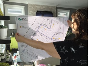 Shilo Wilson looks at a map depicting where the temporary water supply lines will be run in Saskatoon's Aspen Ridge neighbourhood as the city continues to investigate how hydrocarbons found their way into seven nearby fire hydrants, on February 3, 2018. (Erin Petrow/ Saskatoon StarPhoenix)