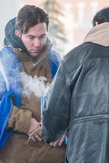 A man smudges while protesters gather outside of Regina's Queen's Bench Court on Feb. 10, 2018, the day after Gerald Stanley was acquitted of all charges relating to the shooting death of Colten Boushie.