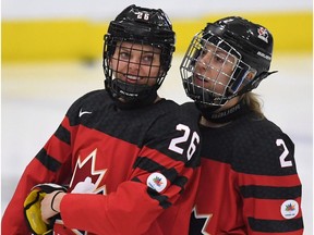 Canada's Emily Clark (26) and Meghan Agosta ( 2) talk before before the start of the IIHF women's world championship preliminary round game against Russia.