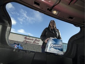 Caitlin Christoph, owner of the Booze Crew Courier Services Inc., puts a case of beer in her trunk at the Victoria Avenue East Liquor Store in Regina.