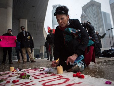 Barbara Manitowabie lays flowers on a memorial for Colten Boushie as protesters gather in Nathan Phillips Square in Torontoon Saturday, Feb. 10, 2018, to protest the verdict in his murder trial.