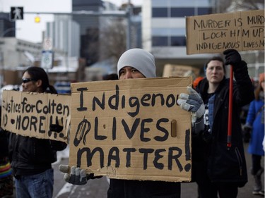 People gather with signs during a rally in response to Gerald Stanley's acquittal in the shooting death of Colton Boushie in Edmonton, Alta., on Saturday, February 10, 2018.
