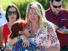 Parents wait for news after a reports of a shooting at Marjory Stoneman Douglas High School in Parkland, Fla., on Wednesday, Feb. 14, 2018.