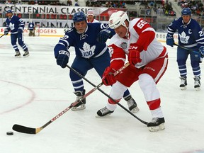 Tiger Williams of the Toronto Maple Leafs Alumni chases Larry Murphy of the Detroit Redwings Alumni at Exhibition Stadium during f the Centennial Classic Alumni Game in Toronto on Saturday December 31, 2016. Dave Abel/Toronto Sun/Postmedia Network