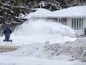 People clear snow along 33rd Street West in Saskatoon, SK on Monday, March 5, 2018.