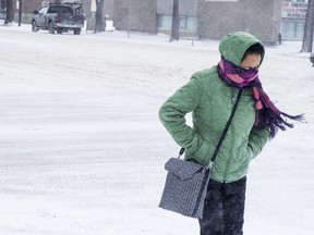 A woman crosses the street during a snowy day in Saskatoon, SK on Saturday, March 3, 2018.