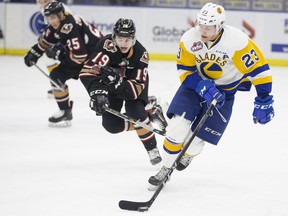 Saskatoon Blades forward Braylon Shmyr controls the puck as Calgary Hitmen forward Carson Focht (19) and Calgary Hitmen forward Cael Zimmerman (25) pursue him during WHL action Friday at SaskTel Centre in Saskatoon.