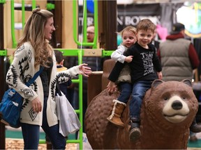 Maisie and Bennett Robertson ride a bear at a playground display during the annual HomeStyles event at Prairieland Park in Saskatoon, SK on March 11, 2018.