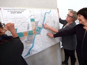 Point-in-Time (PIT) Count Coordinator Colleen Christopherson-Cote (center) and Dr. Isobel M. Findlay (right) look at a map of Saskatoon, which highlights the survey on homelessness study areas, during an information session about the 2018 Point in Time Count of Homelessness in Saskatoon, which is taking place on April 18 at Station 20 West in Saskatoon on March 14, 2018.