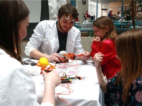 Graduate student Andrew Roebuck, department of physiology, shows Leila Dunning how to use Electromyography (EMG) to control a robotic claw as part of brain awareness week during Brain Blast at Saskatoon City Hospital on March 18, 2018.