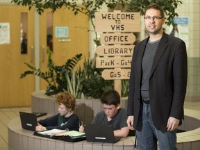 Ron Biberdorf, principal of Venture Heights elementary school, right, stands for a photograph as Kaleb Braun, left, and Emilio Rodriguez work on laptops in the entrance lobby of the school in Martensville, SK on Wednesday, March 21, 2017.