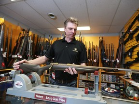 Kevin Kopp, owner of North Pro Sports, is surrounded by rifles for sale in his shop in Saskatoon, SK on March 28, 2018.