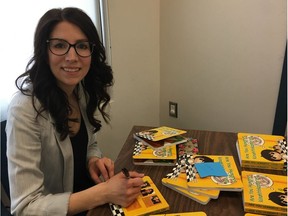Calyn Stange is pictured with copies of the children's book she wrote, Are You Hungry? The books were written in Cree/English, Dene/English and Michif/English and will be distributed to children 18 months old in Northern Sask.
