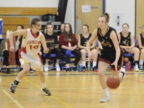 Centennial Charges player Kaitlin Jockims (12) dribbles the ball up court while Carlton Crusaders point guard Payton Izsak (10) stays with her during the Hoopla 5A bronze medal game on Saturday, March 24, 2018 from Prince Albert.